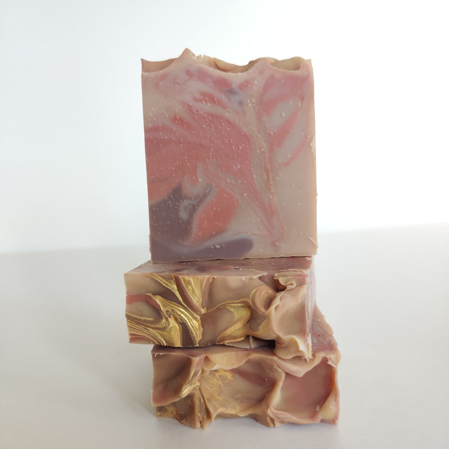 Labyrinth Beauty Gretel's Dream soap. Pink and purple swirls with light brown background. Soap top is decorated with gold swirls