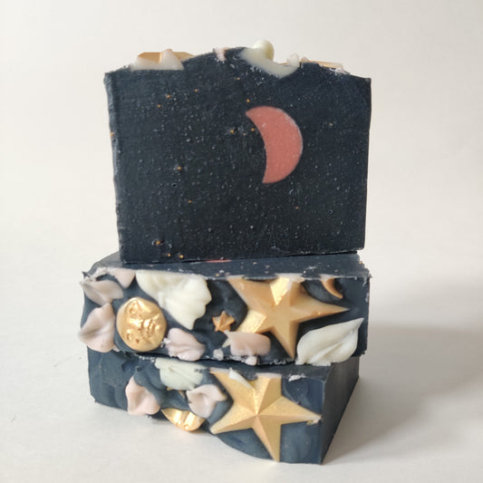 Labyrinth Beauty Under The Strawberry Moon Soap. Black with pink moon design. Gold moon and stars with flower petal decorations.